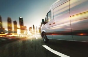 white truck with motion blur background speeds through night traffic in Grand Rapids